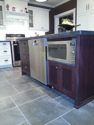Custom stained island with microwave and dishwasher.