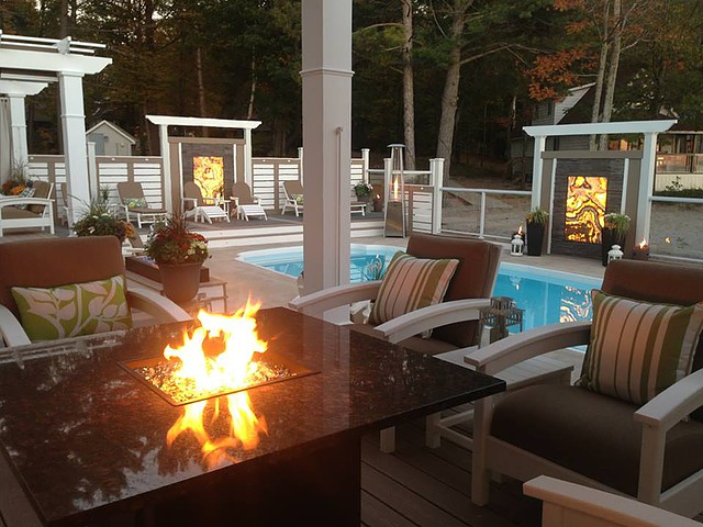Picture Landscaped pool deck, fire table back lit onyx stone panels, pool