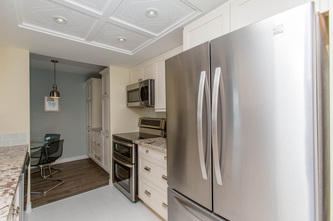 tray ceiling with pot lights, stainless steel appliances in condo