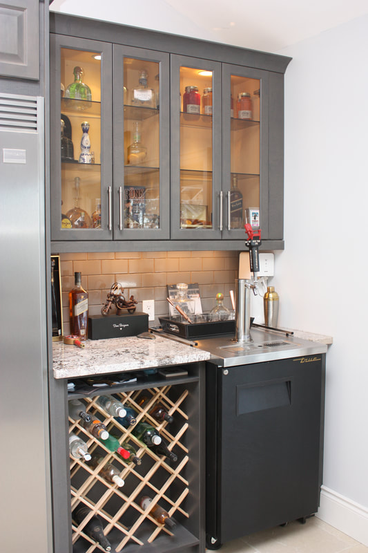 Picture. Custom built bar area with Kegerator, glass upper cabinets to display bottles and custom built wine rack.