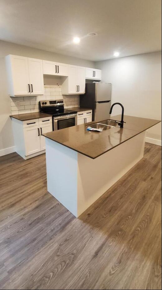 Basement apartment kitchen Orillia with island and stone countertop.