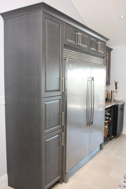 Picture. Custom Kitchen pantry with pullouts, custom stainless side by side fridge and freezer, raised panel kitchen cabinet doors.
