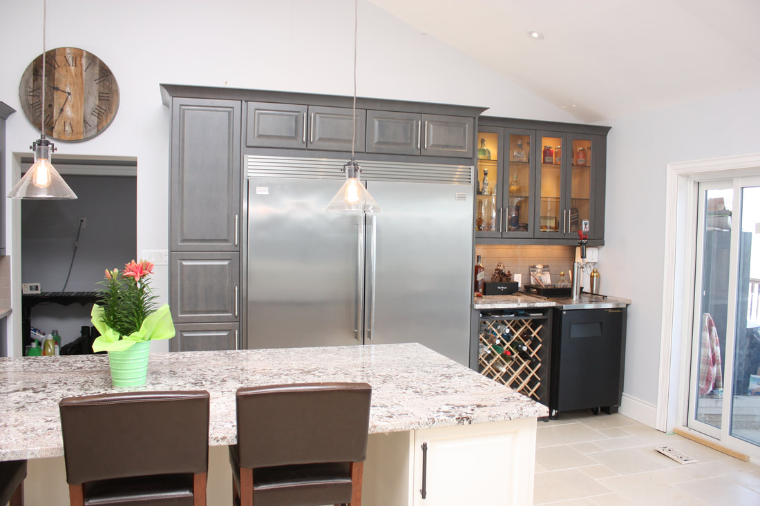Picture. Custom Kitchen Side by side built in stainless steel fridge and freezer. Custom bar area with Kegerator, glass upper cabinets and custom wine rack.